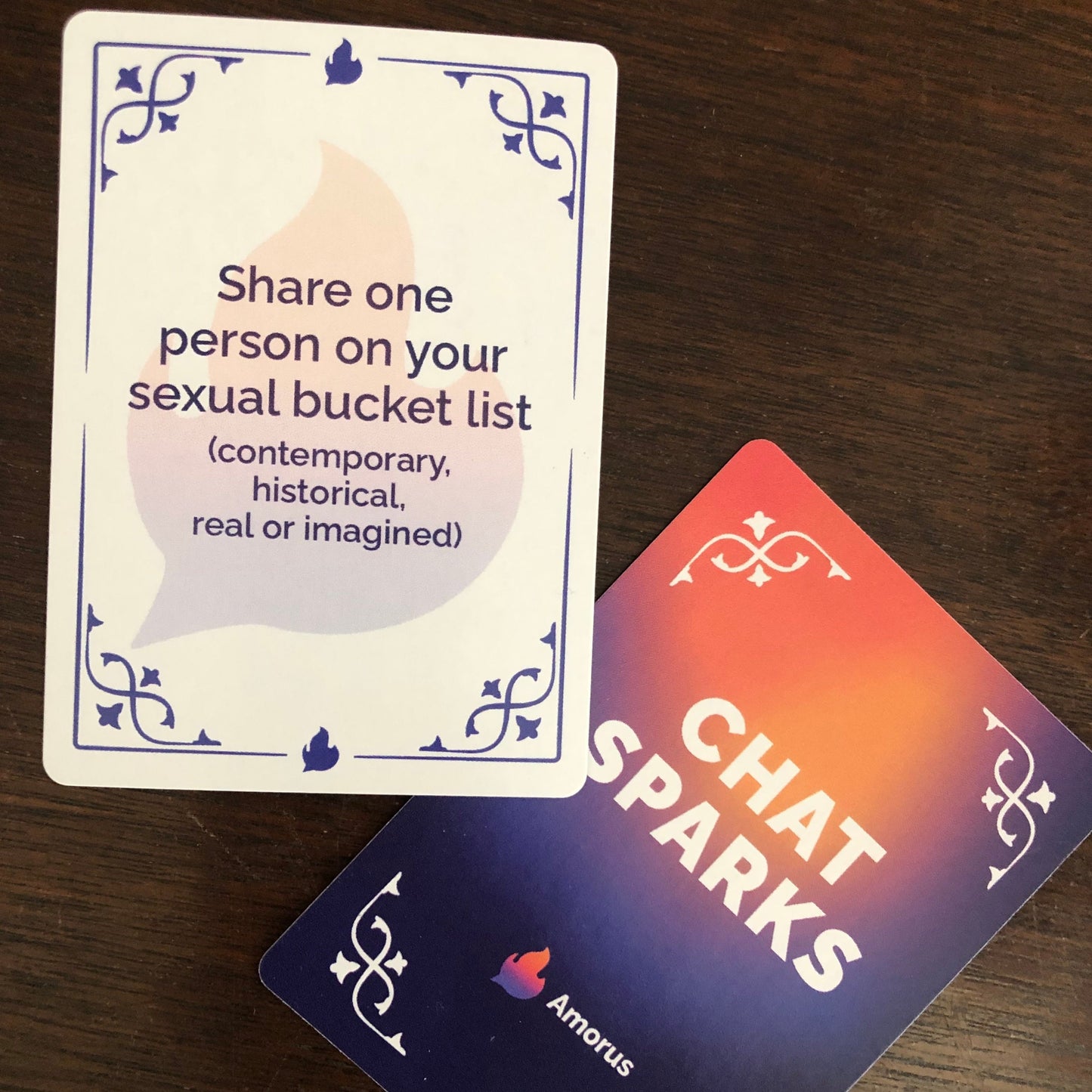 Image of Chat Sparks game card on table. Card reads "Share one person on your sexual bucket list (contemporary, historical, real or imagined)."